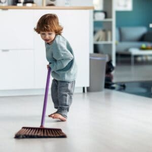 boy sweeping kitchen floor