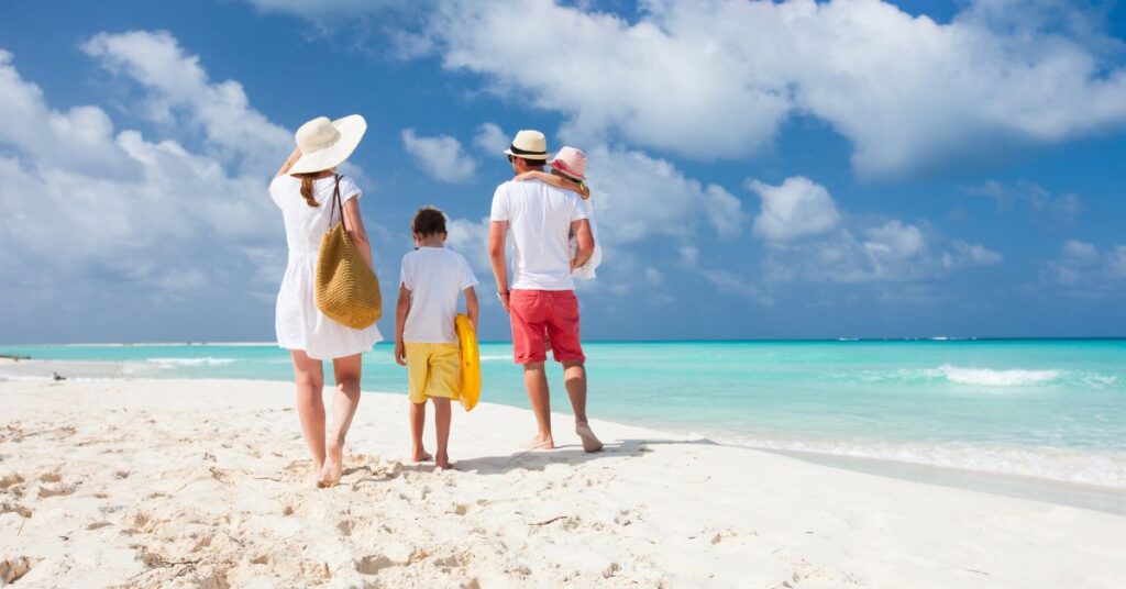 A family of four walking along a sunny beach