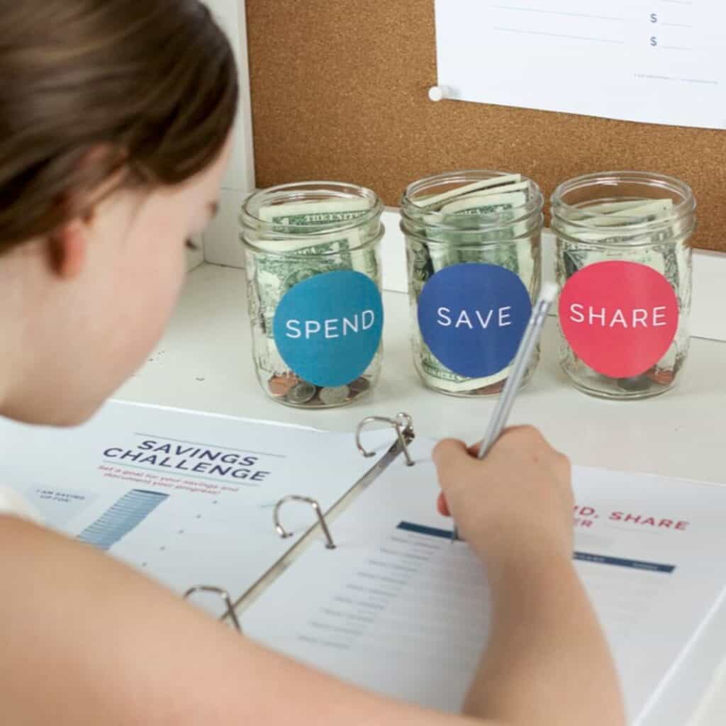 child looking over kids money management toolkit and spend save share jars