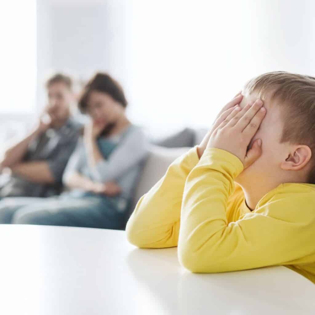 upset child facing punishing consequence as parents look on