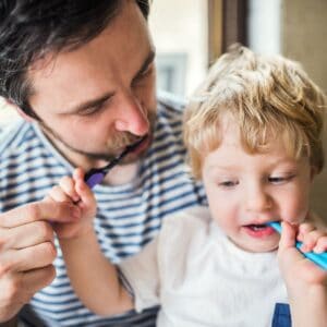 brushing teeth for kids - a boy and his father brushing their teeth