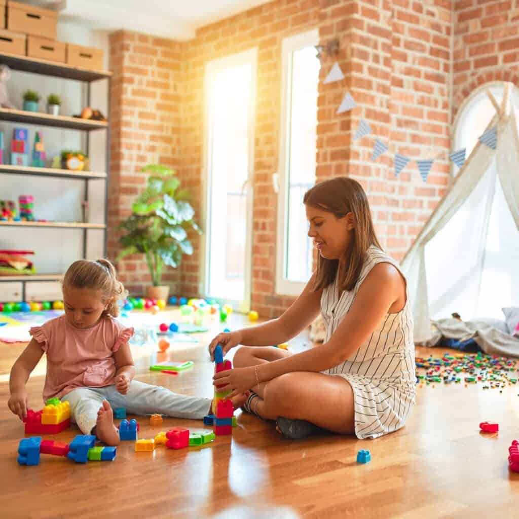 mother and daughter playing with blocks in playroom