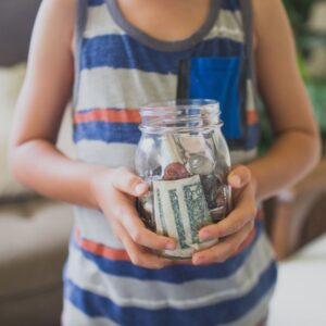boy holding a jar of money