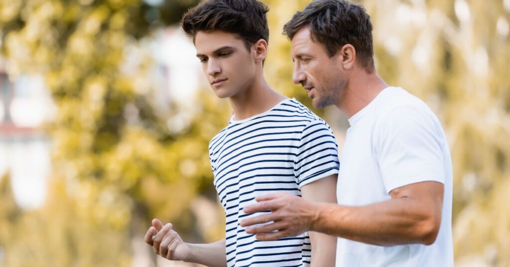 A father talking to their son while walking - questions to ask teenagers